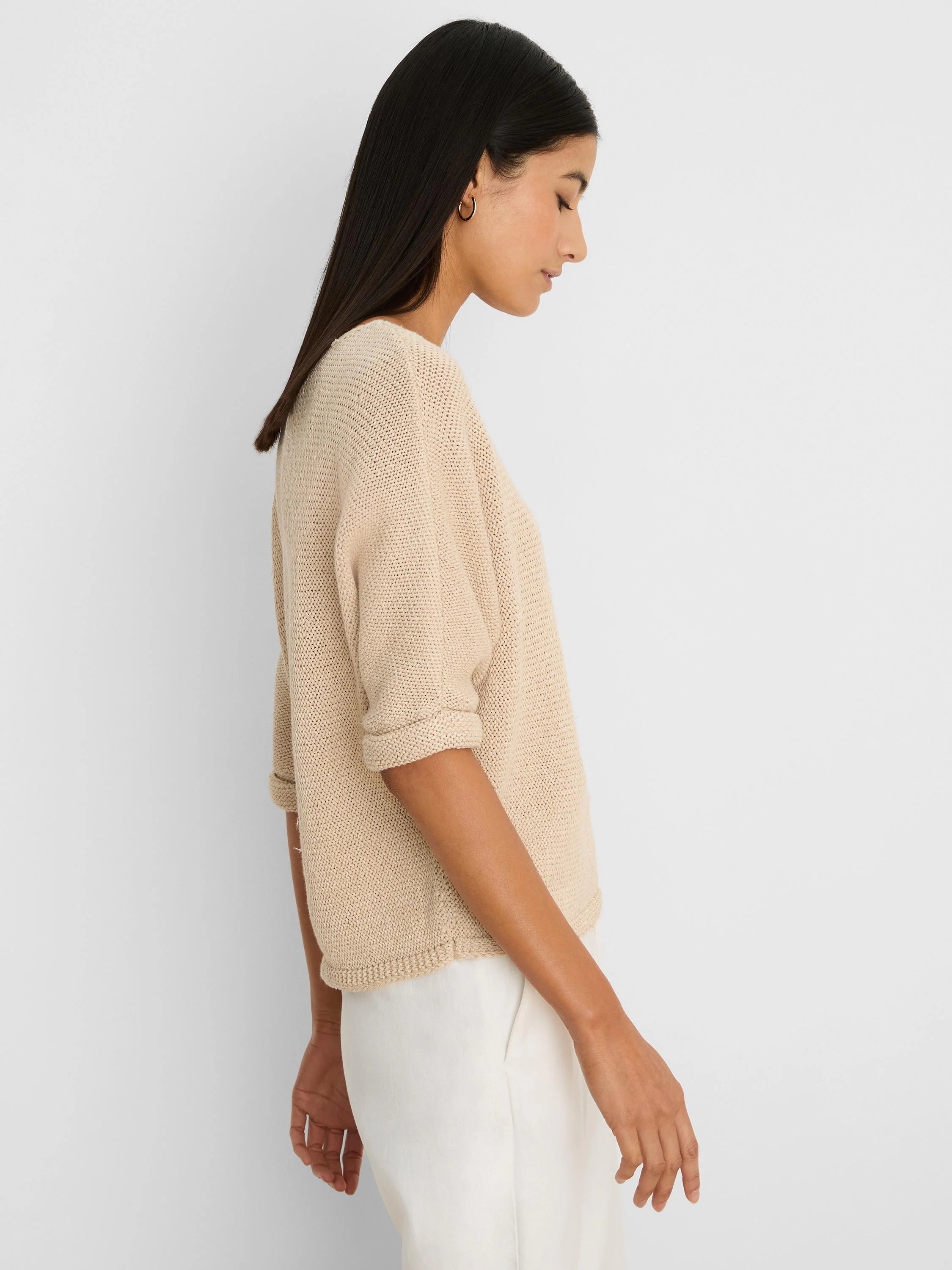 Beige crimpy-knit sweater with elbow-length rolled cuffs and a relaxed fit.