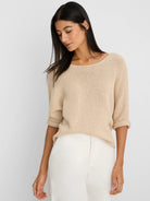 Beige textured knit sweater with a wide neckline and 3/4 length rolled sleeves.