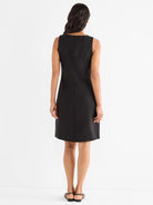 Black sleeveless shift dress features a straight fit and center back seam.