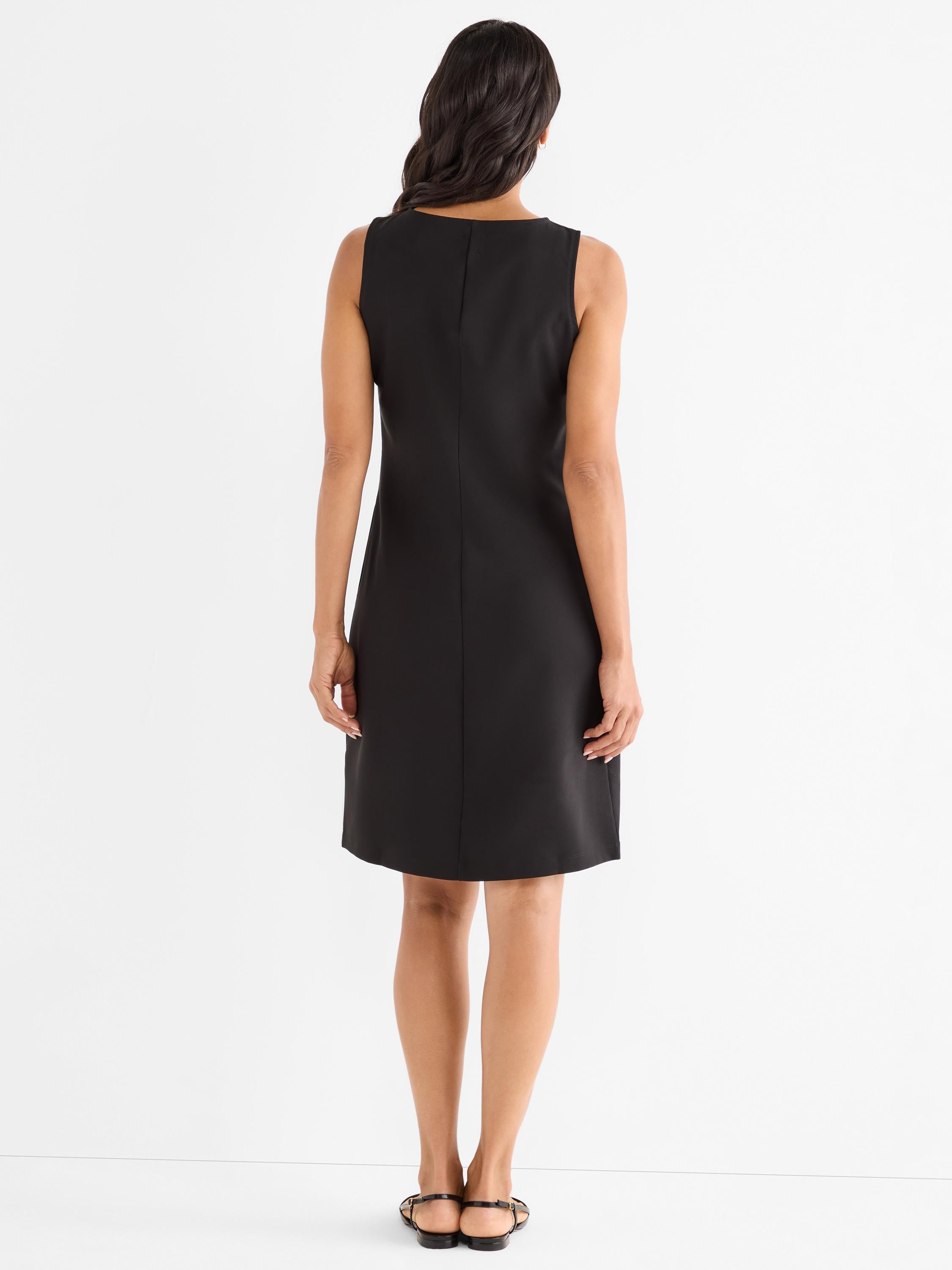 Black sleeveless shift dress features a straight fit and center back seam.