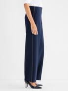 Navy high-waisted wide-leg trousers with white contrast stitching detailing the outer seams.
