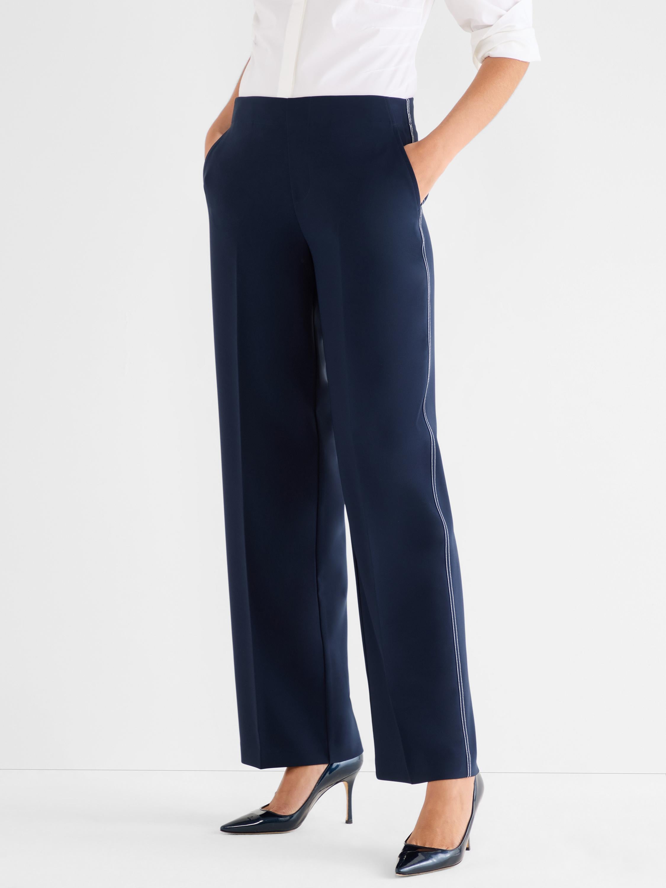 Navy wide-leg trousers feature a high waist and white contrast piping detail along the outer seams.