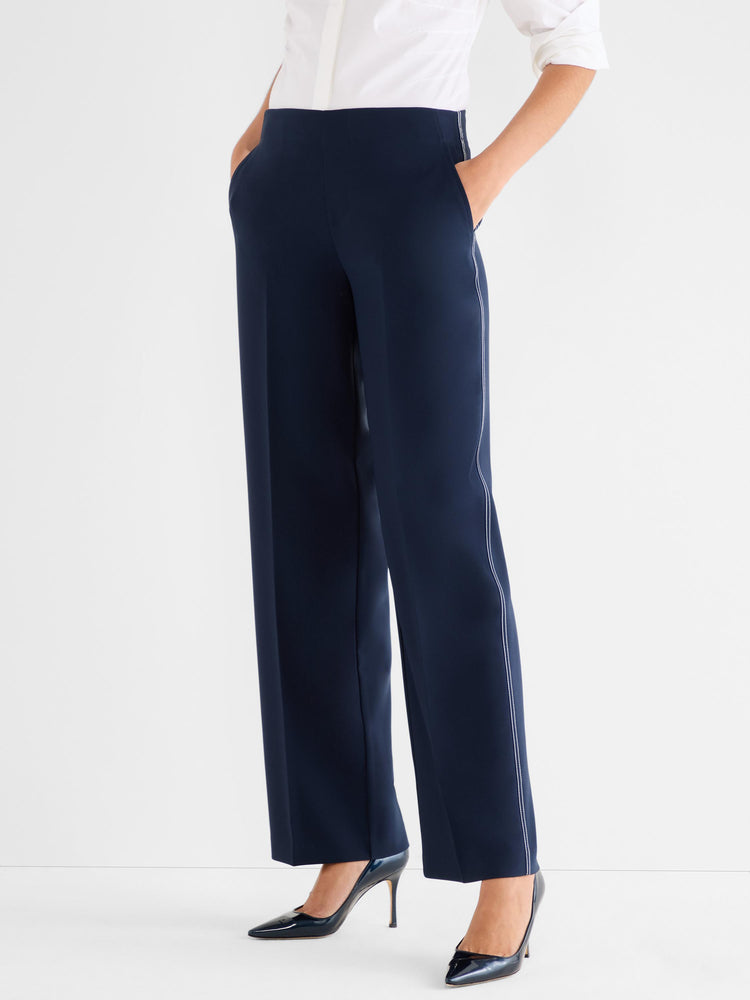Navy wide-leg trousers feature a high waist and white contrast piping detail along the outer seams.