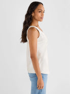 Light cream woven scoop neck tank top with a subtle sheen, worn by a model in profile.