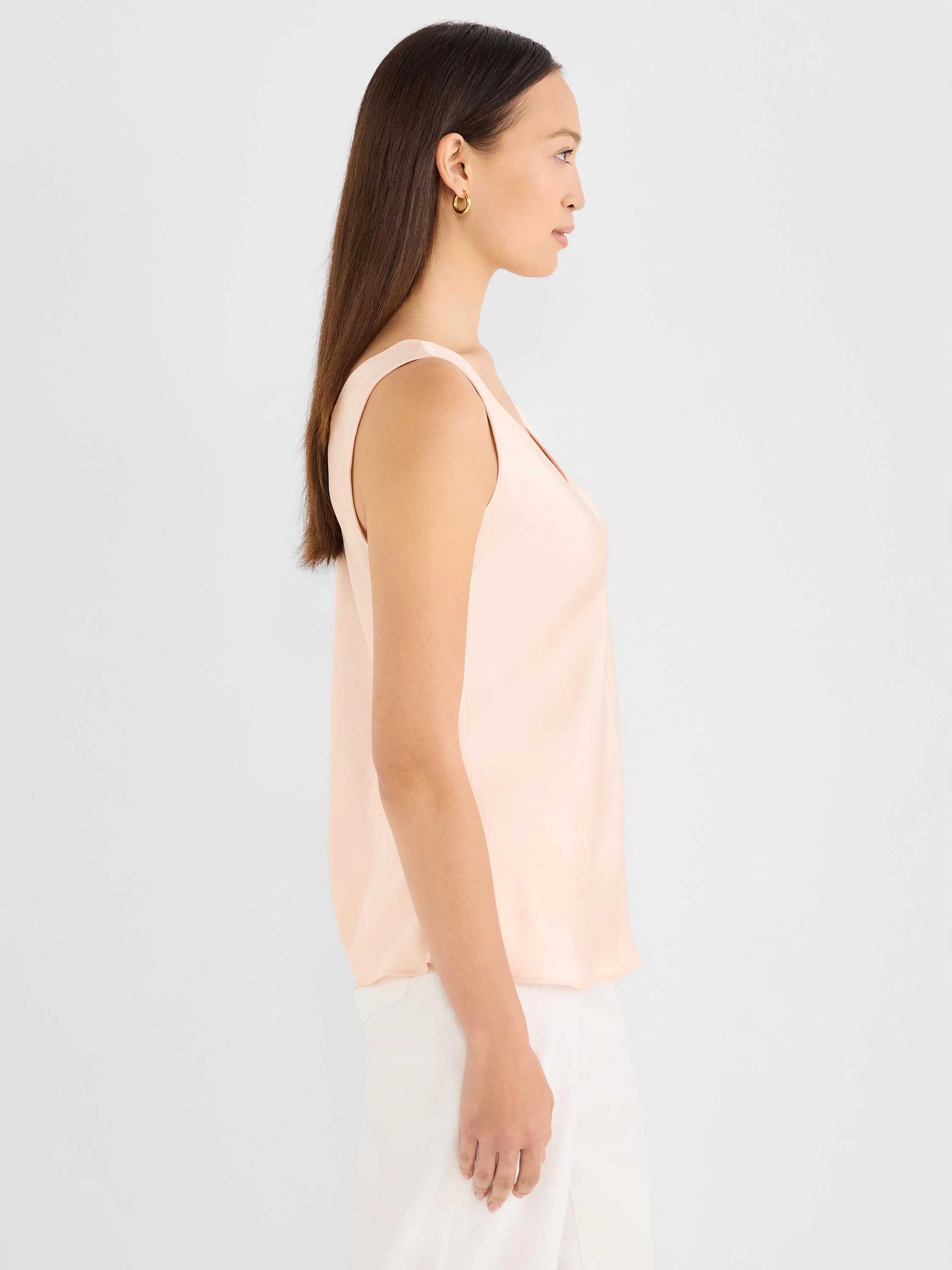 Light peach sleeveless tank with a smooth, glossy woven texture and a V-neck.