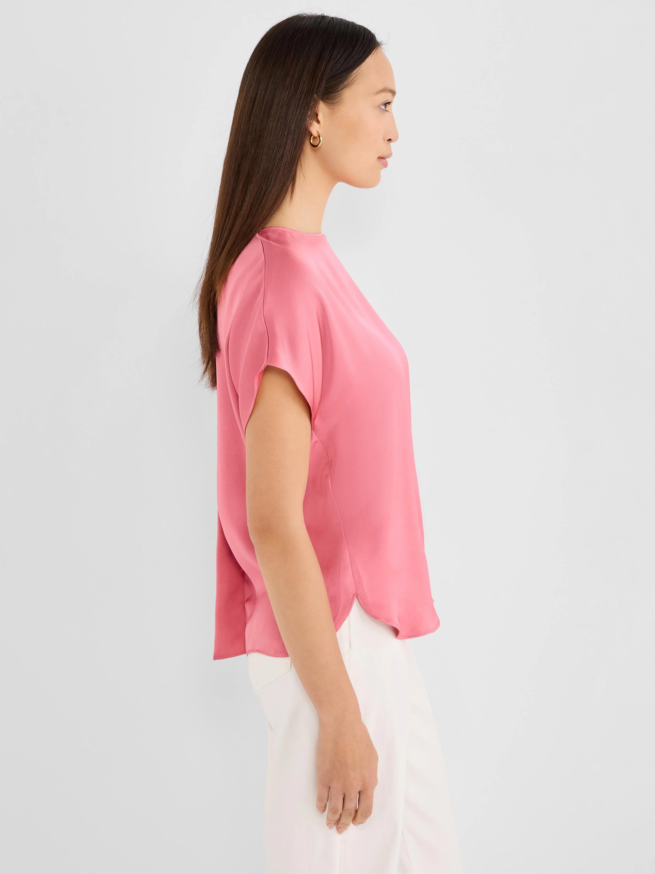 Bright pink, loose-fit tee with short cap sleeves and a rounded, split hem.