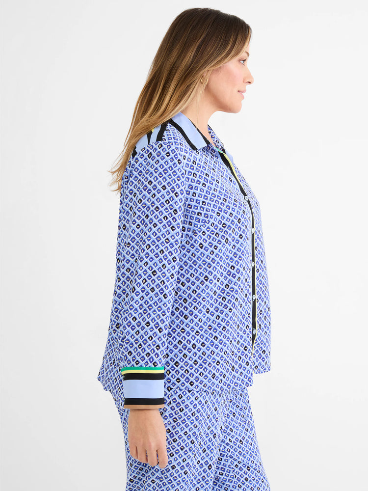 Mosaic print shirt, blue with geometric shapes in black and tan. Striped collar, cuffs, and placket in black, yellow,...