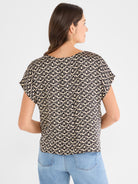 Relaxed black and tan geometric print blouse with a scoop back and short, draped cap sleeves.