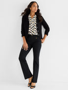 Slim black trousers with front gold stud details are styled with a black three-quarter sleeve knit jacket and blouse.
