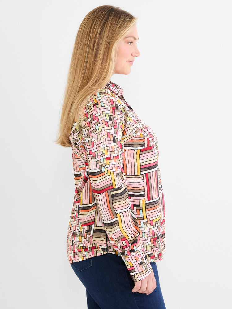 A relaxed fit long-sleeve blouse featuring a vibrant multicolored abstract geometric print is worn by the model.