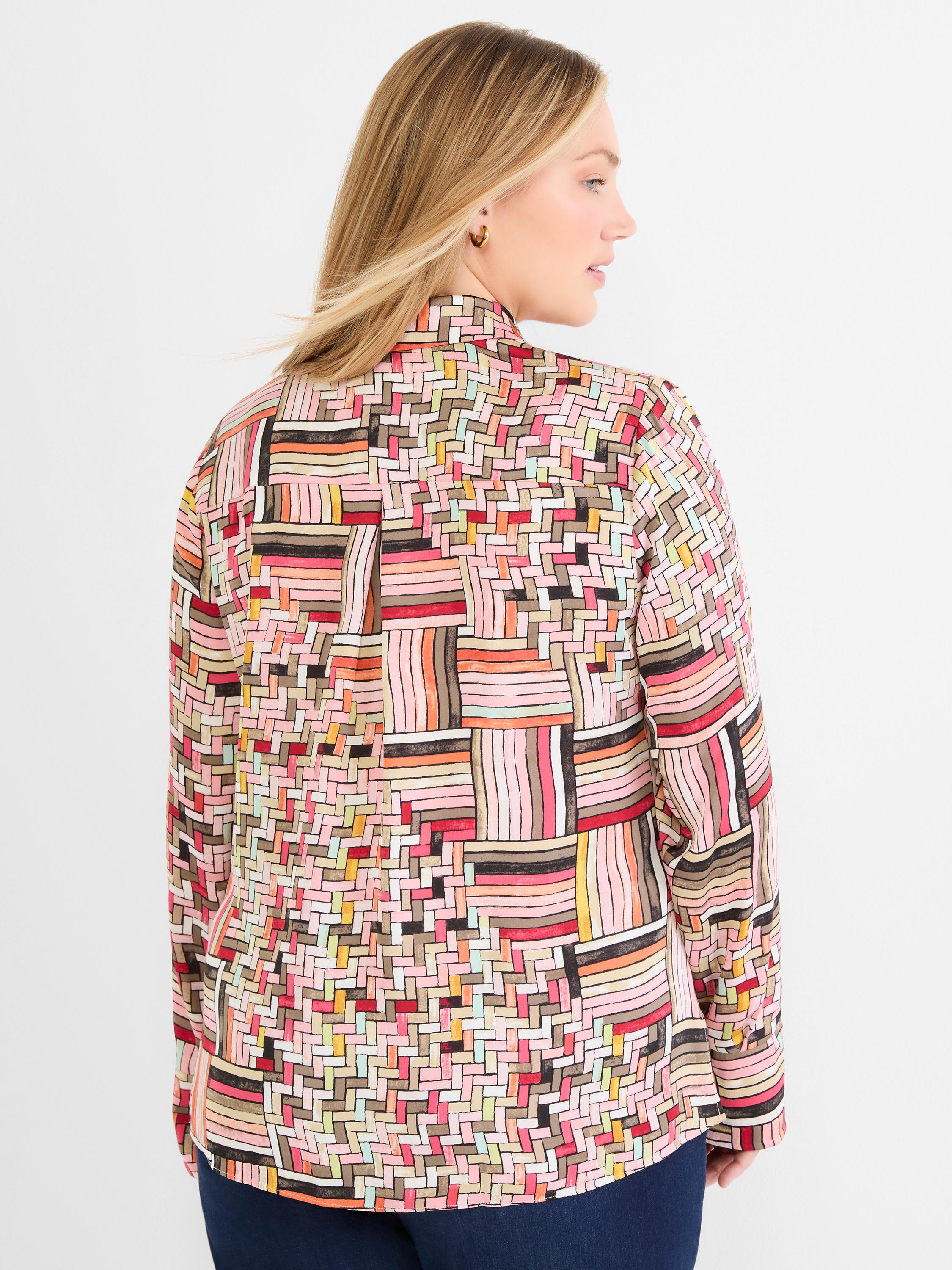 A model wears a relaxed fit, long sleeve blouse with a vibrant, multicolored abstract geometric weave pattern.