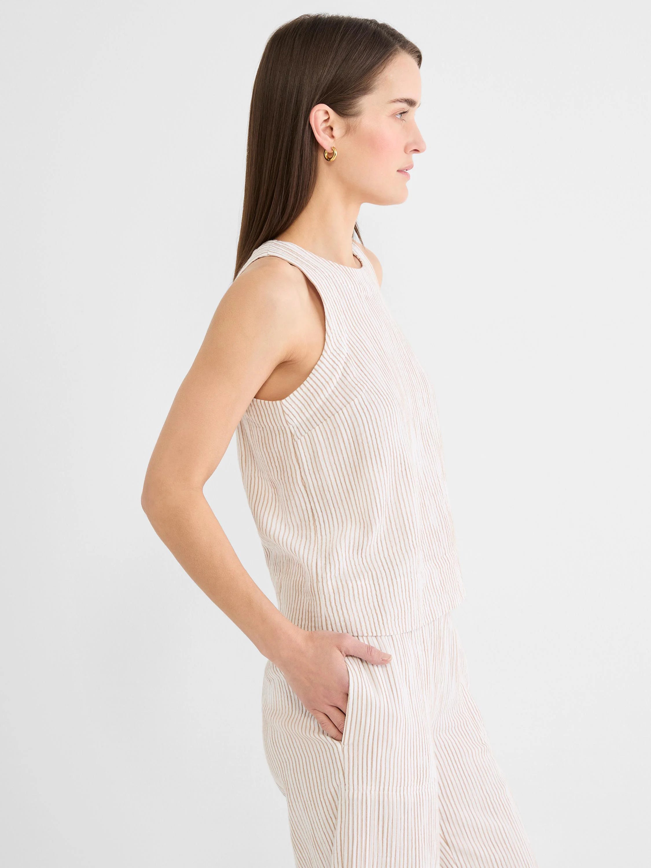 Cream gauze tank with thin brown vertical pinstripes and a round neck.