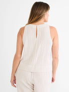 Cream gauze tank with vertical beige pinstripes. Sleeveless, high neck, and keyhole back with button closure.