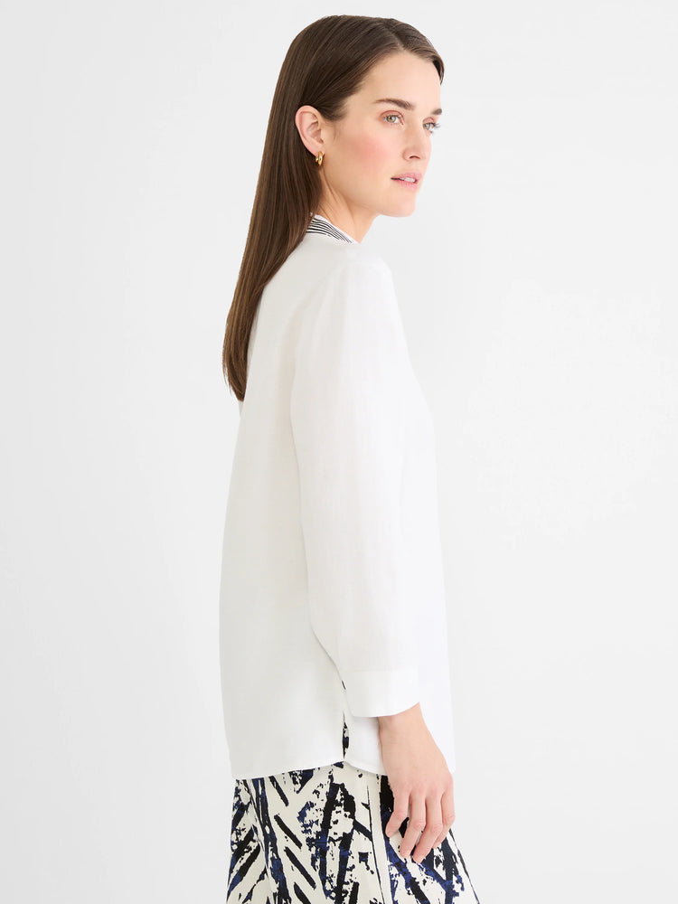 White linen shirt with long sleeves, black and white striped collar trim, and side slits.