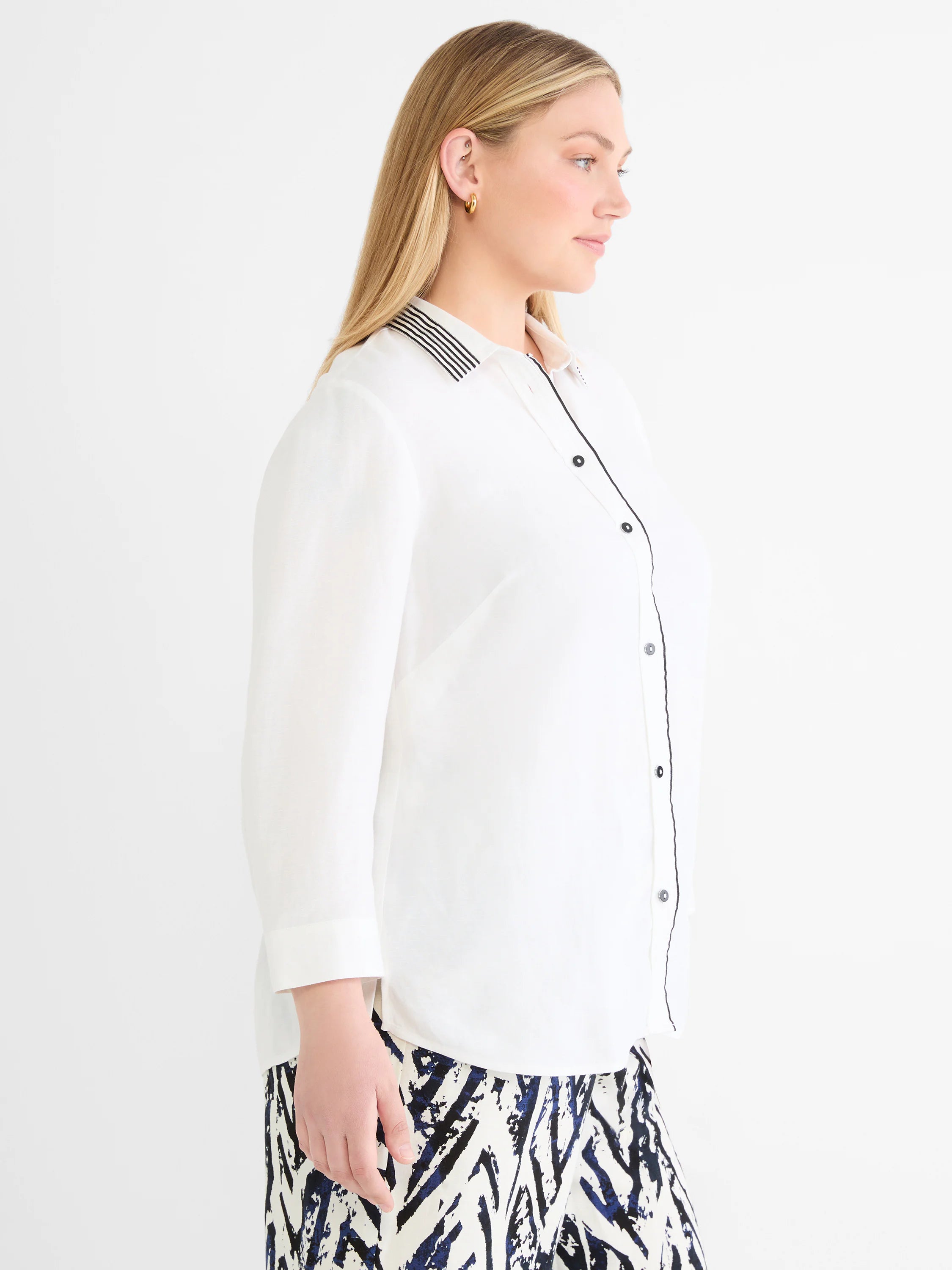 White linen shirt with black striped collar, black piping along the button placket, and black buttons.