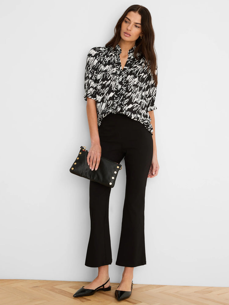Black and white top with a scribbled cursive pattern, ruffled stand collar, and short sleeves.