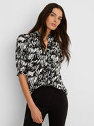 Black and white cursive print top with a ruffled V-neck and short gathered sleeves.