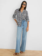 White collared V-neck shirt with irregular dark blue & black zig-zag pattern. Sleeves rolled.
