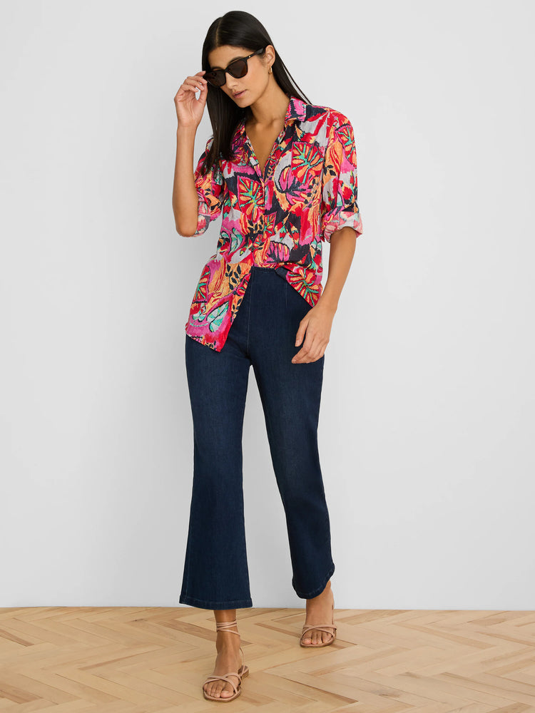 Vibrant crinkle shirt in red, pink, orange, & teal abstract floral pattern. Features a collar & rolled short sleeves.