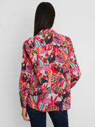 Cotton crinkle shirt with vivid red, pink, orange, teal, black tropical leaf print, viewed from back.