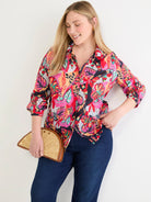 Multi-color crinkle button-down shirt with abstract pink, red, orange, teal, black floral pattern. Rolled sleeves.