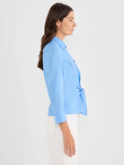Light blue collared shirt with long sleeves, a chest pocket, and a tie front at the waist.