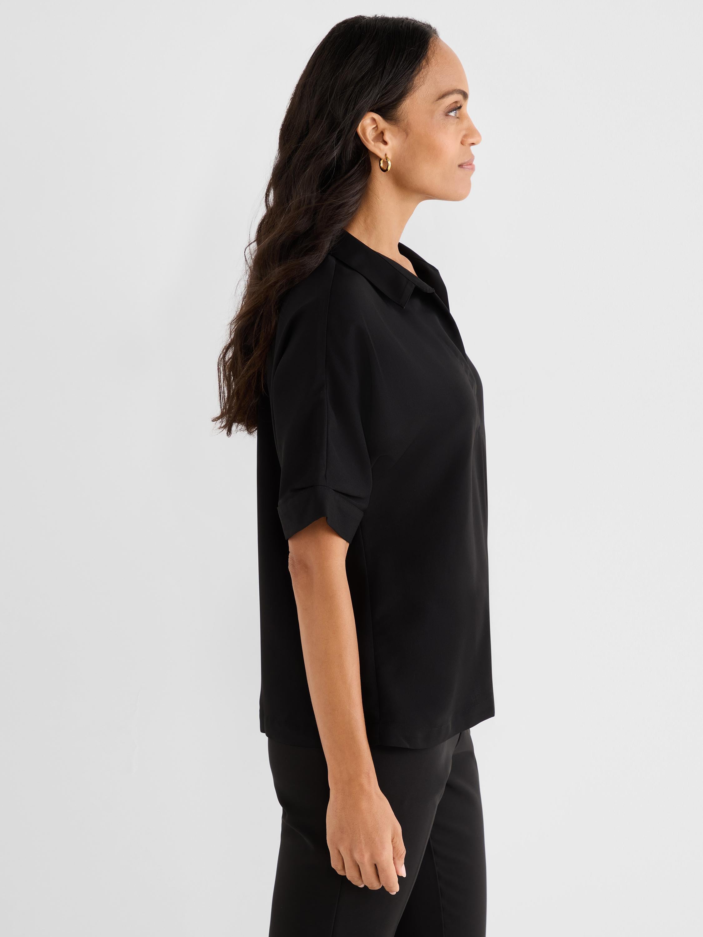 This relaxed fit black short-sleeve blouse features an open collar and stylish cuffed sleeves.