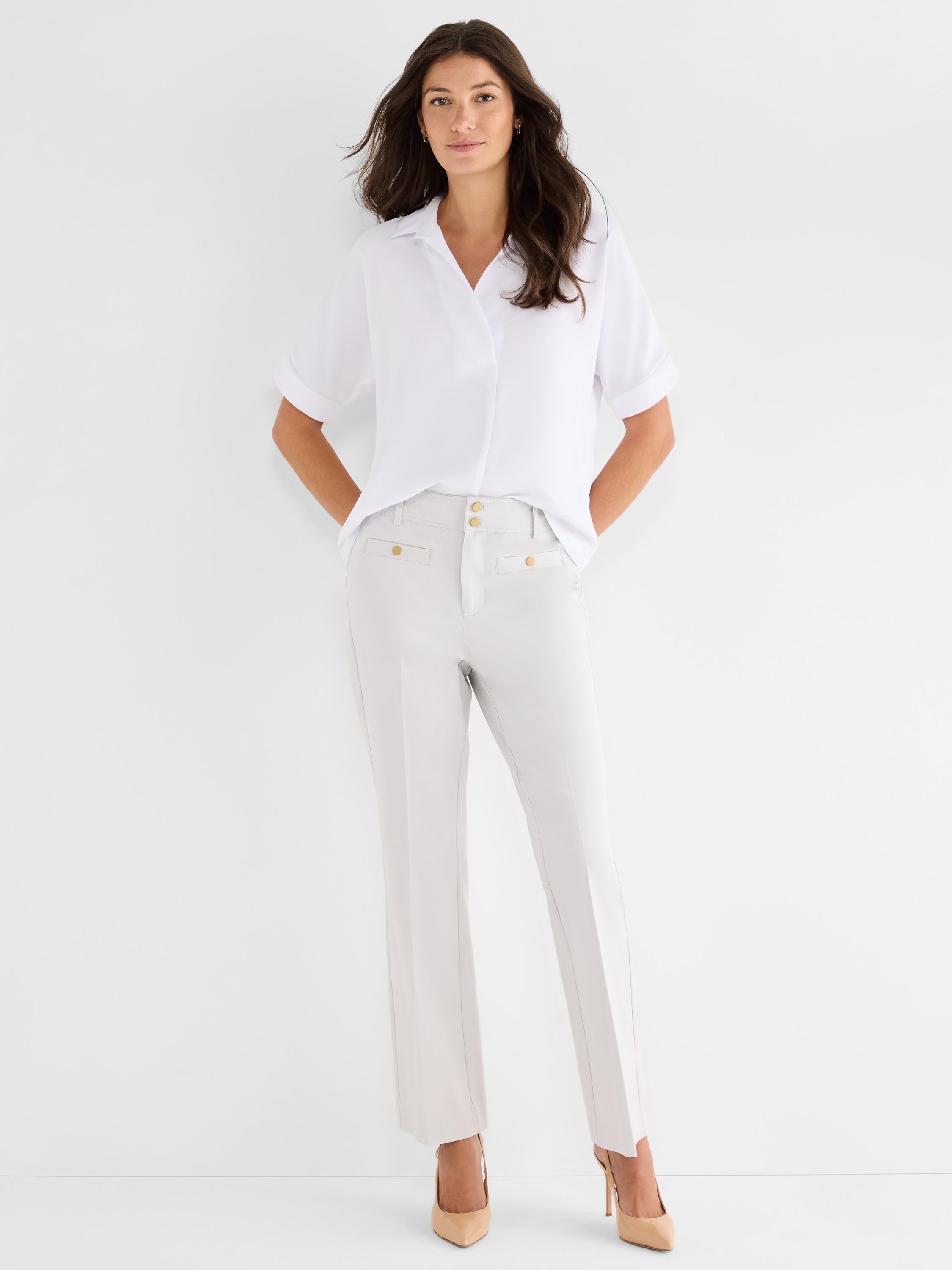 Stone high-waisted trousers with gold hardware and a tailored straight fit are styled with a white collared blouse.