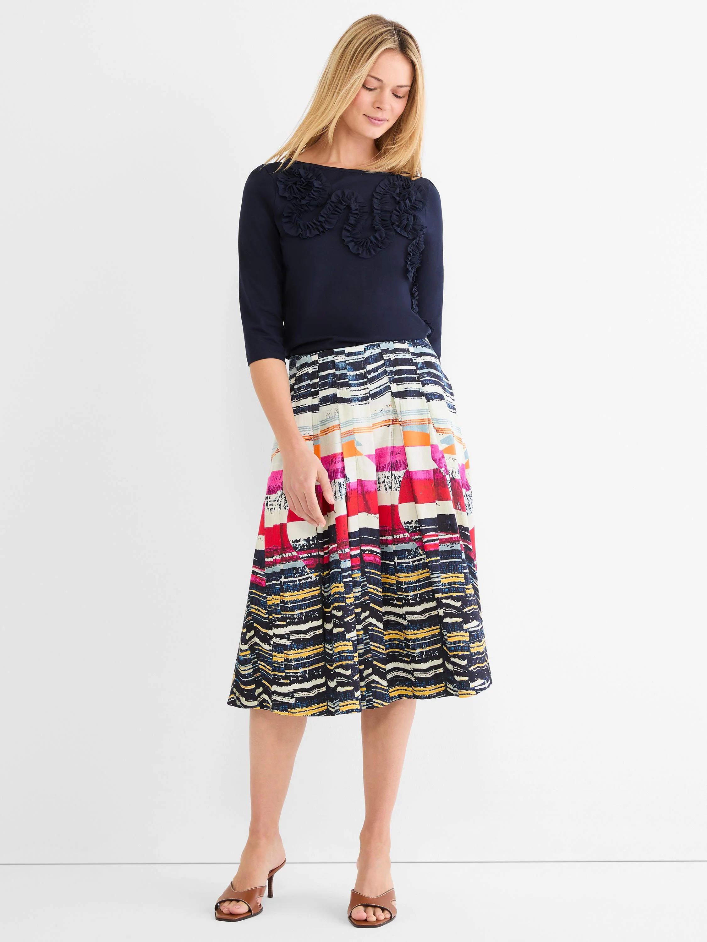 Pleated midi skirt with colorful, abstract horizontal stripes in red, orange, yellow, pink, and shades of blue.