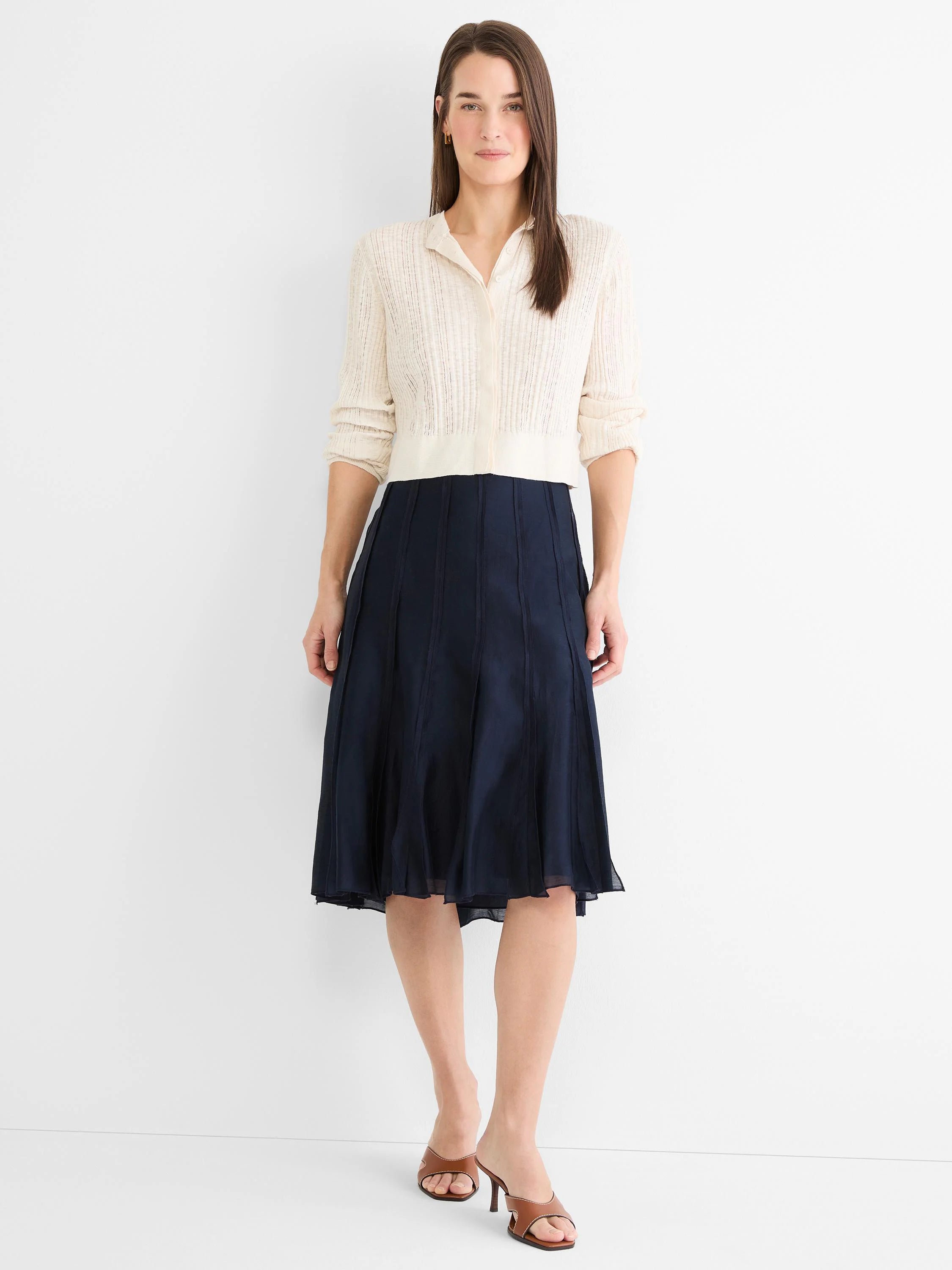 Dark blue knee-length skirt with vertical panel details and a subtle flare.