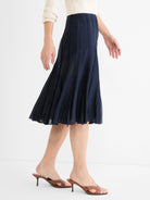 Navy blue flared midi skirt with vertical panel details, worn by a model.
