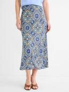 Midi slip skirt with intricate blue, yellow, teal, and white filigree tile pattern on black.