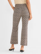 High-waisted cropped trousers are shown with a fitted cut and an all-over black and beige geometric print.