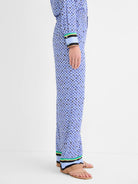 Wide leg pants, blue mosaic pattern with black/gold accents. Hem has tan, light blue, black, green, yellow striped trim.