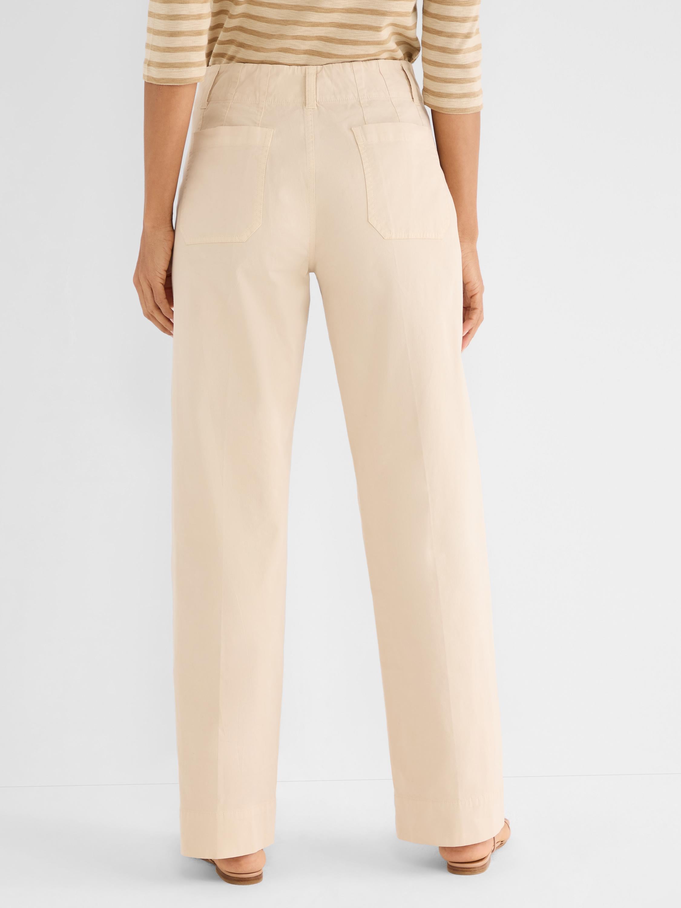 Light beige high-waisted wide-leg pants are shown from the back, detailed with large patch pockets.