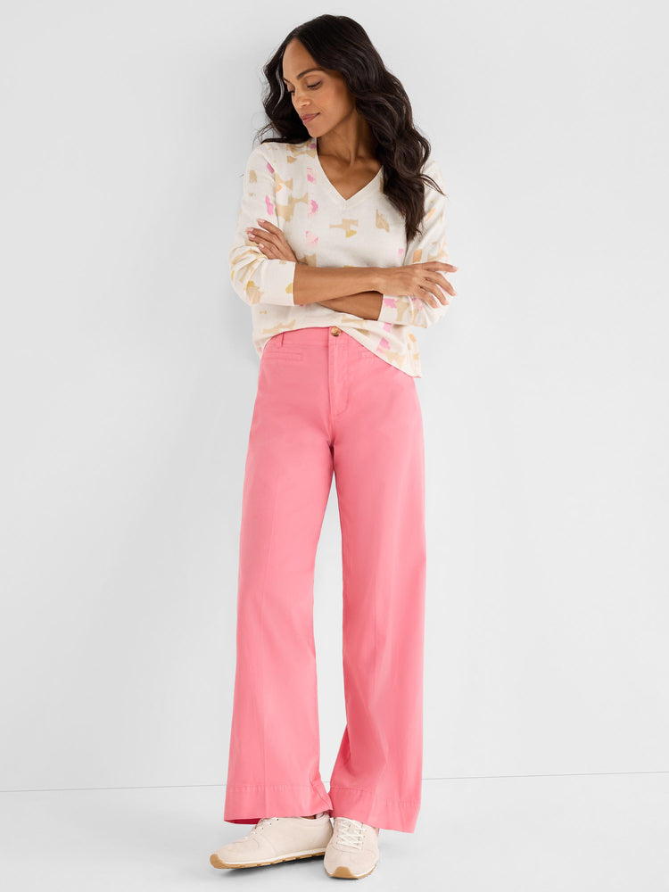 Abstract print V-neck sweater paired with fitted pink high-rise wide-leg pants for a bold casual outfit.