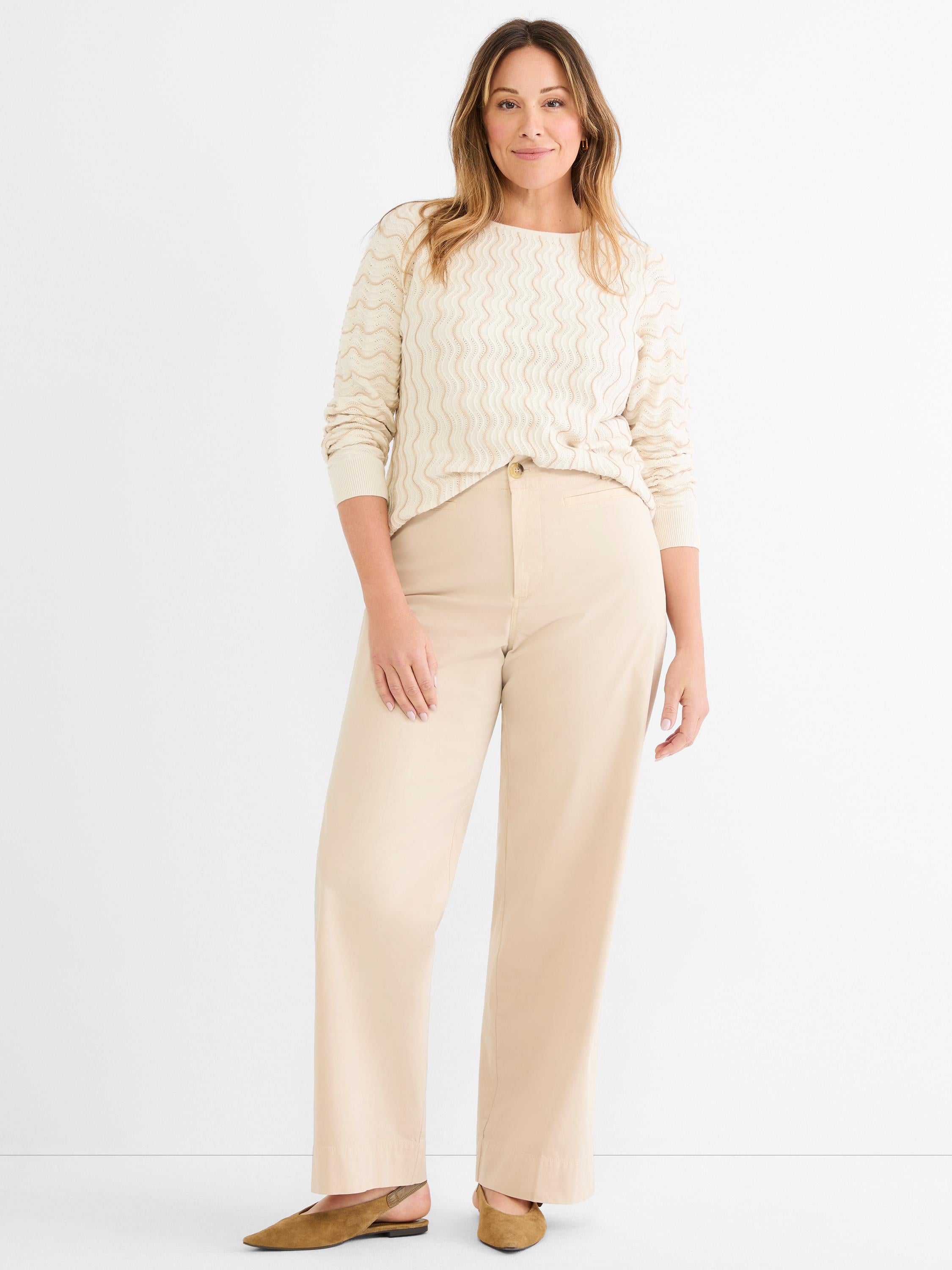Relaxed cream wave-knit sweater and high-waisted wide-leg beige pants create a monochromatic, easy-fitting look.