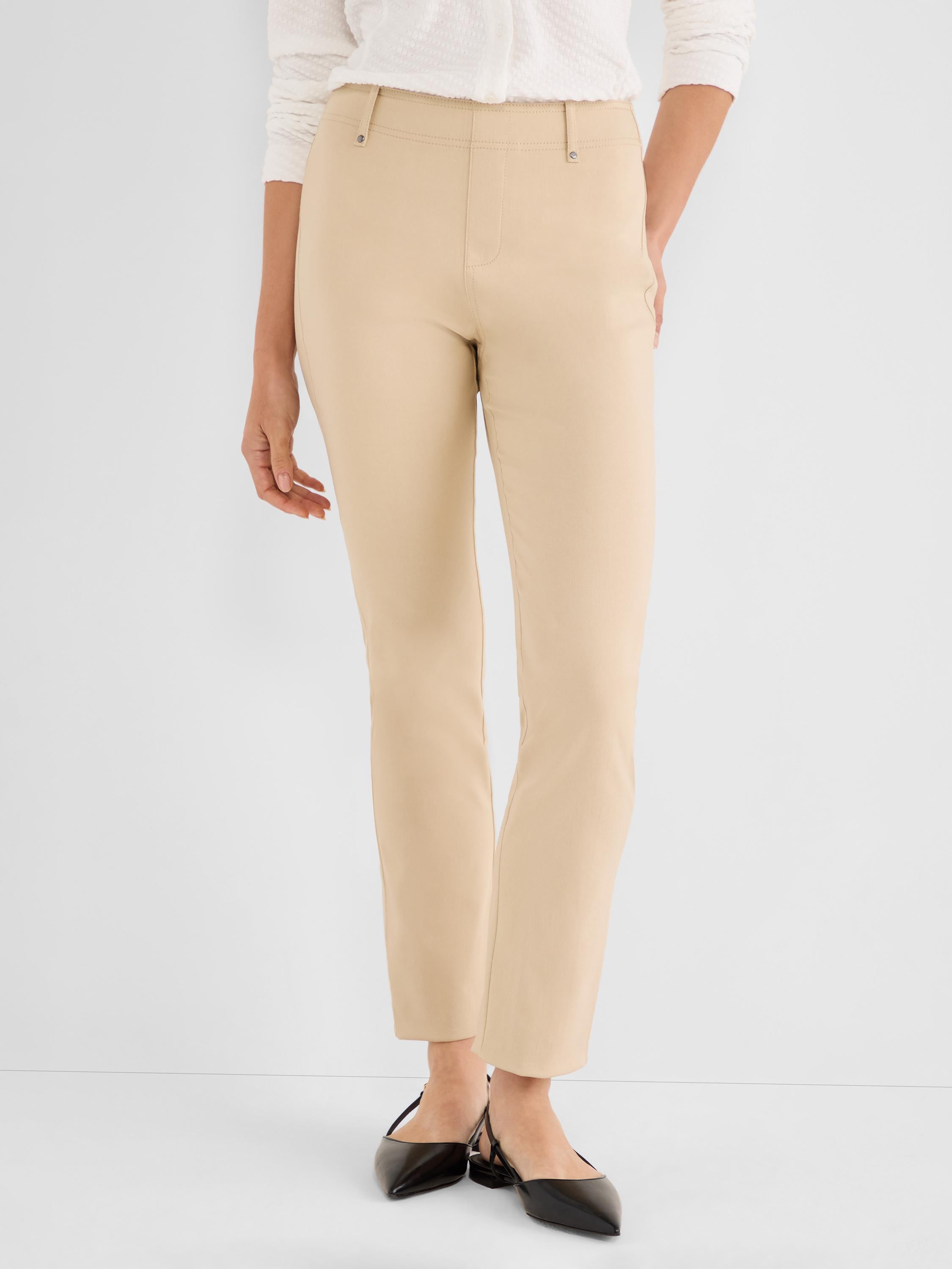 These beige high-rise slim ankle pants feature a clean pull-on waistband detailed with small metal studs.