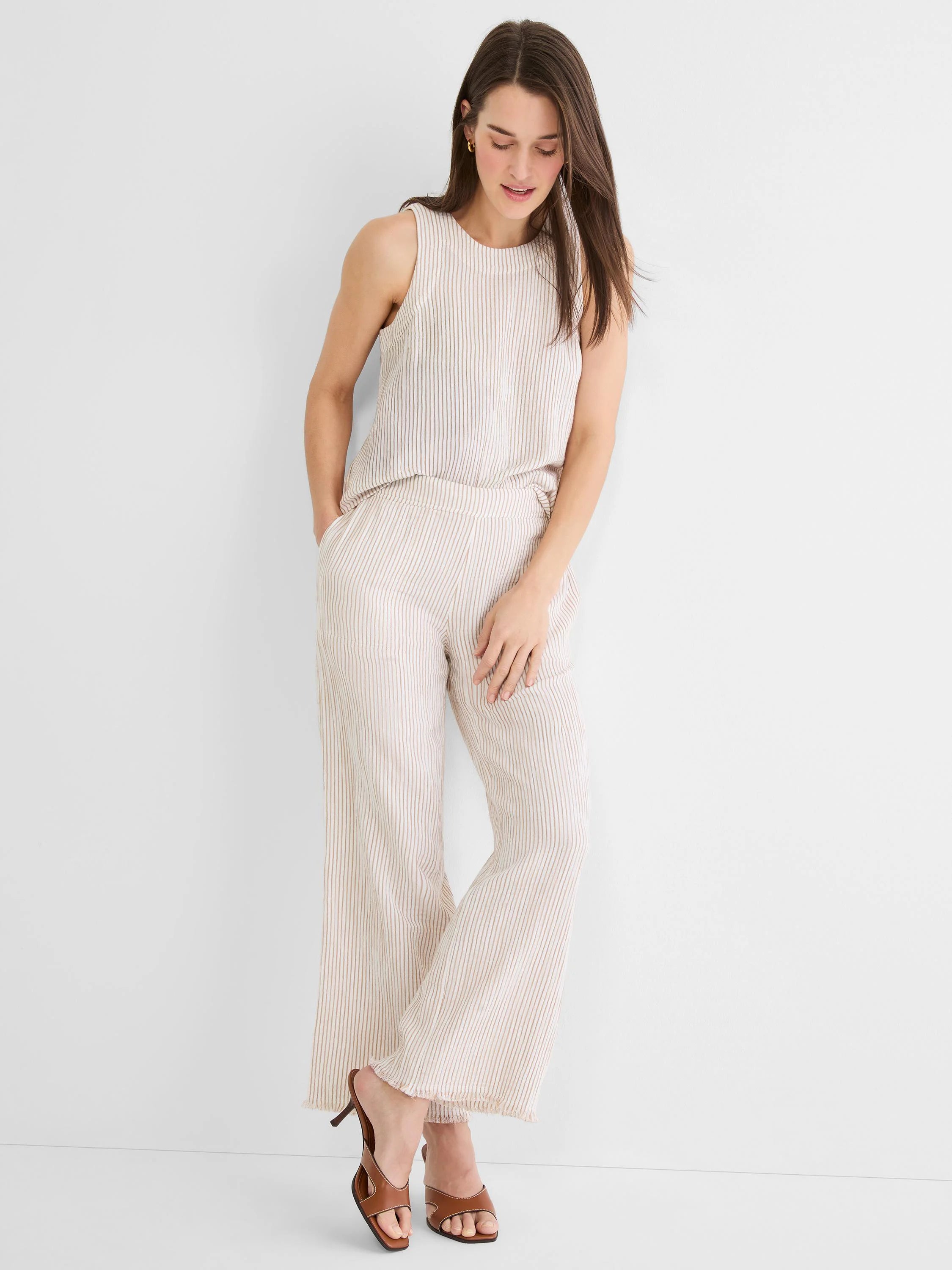 Light beige gauze wide-leg pants with thin brown pinstripes, an elastic waist, and a frayed hem.