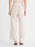 Cream wide-leg pants with vertical tan pinstripes, an elastic waist, and frayed hems.