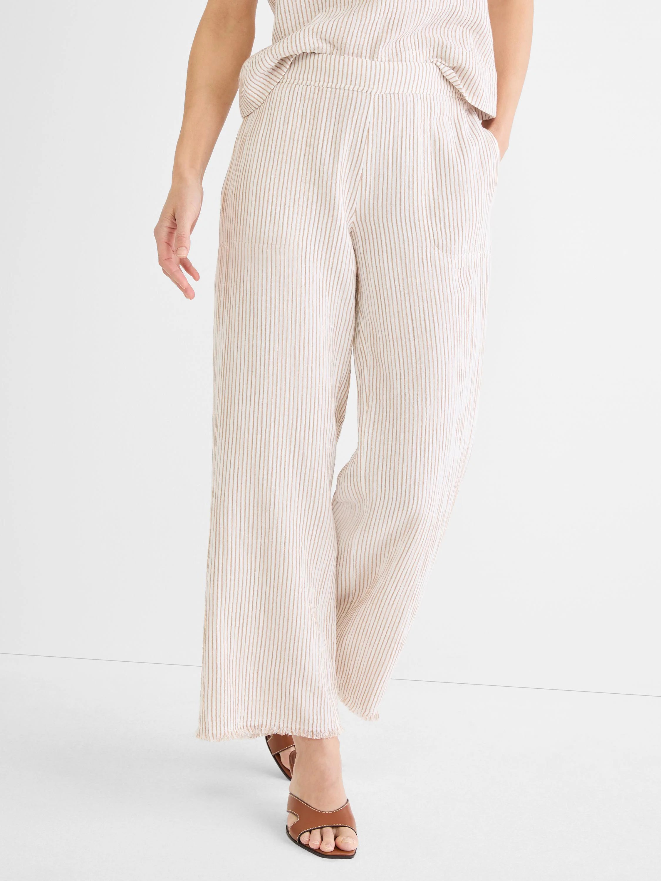 Off-white wide-leg pants with thin tan vertical pinstripes and a frayed hem.
