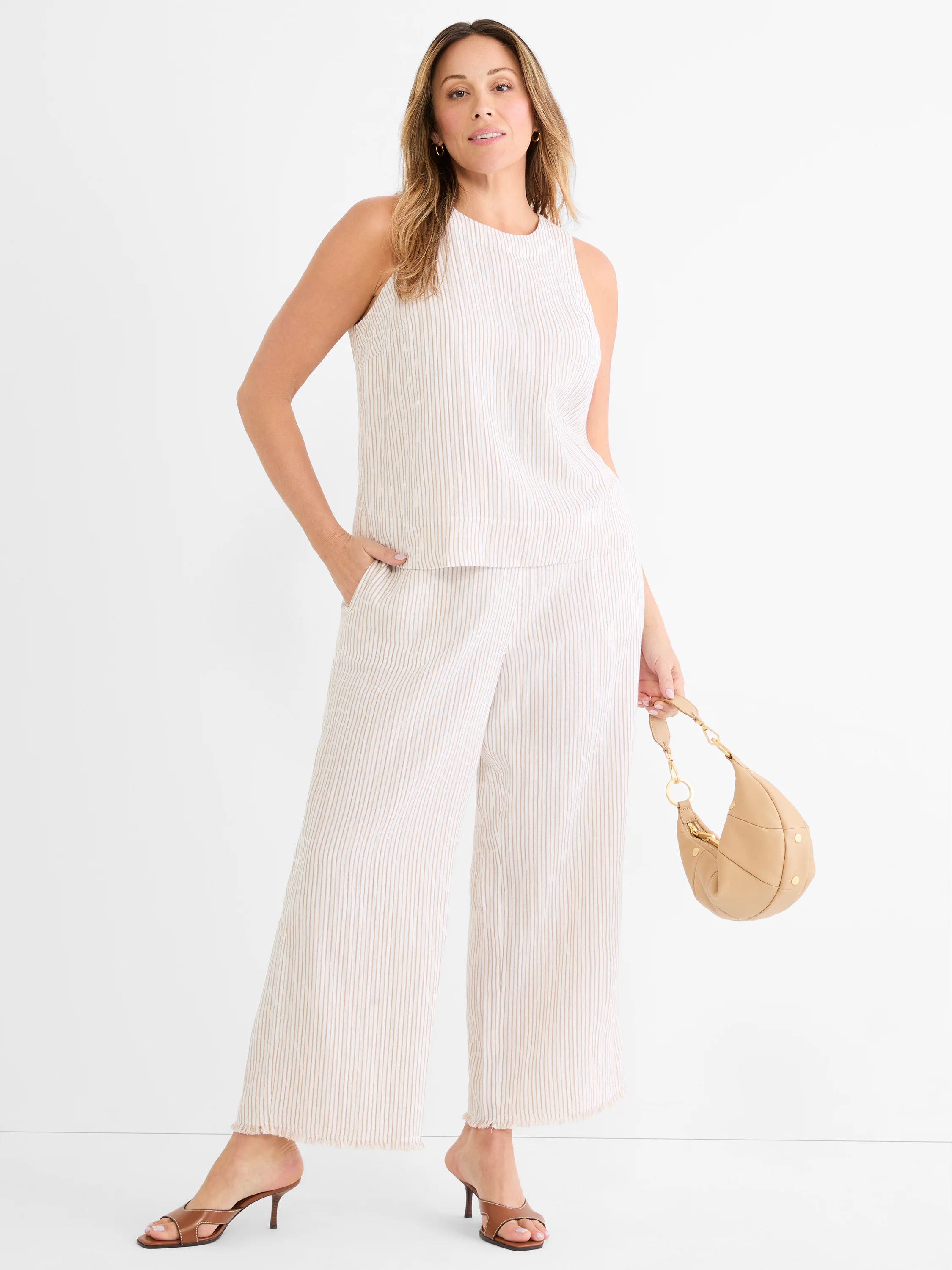 Cream wide leg gauze pants with thin brown pinstripes and a frayed hem.