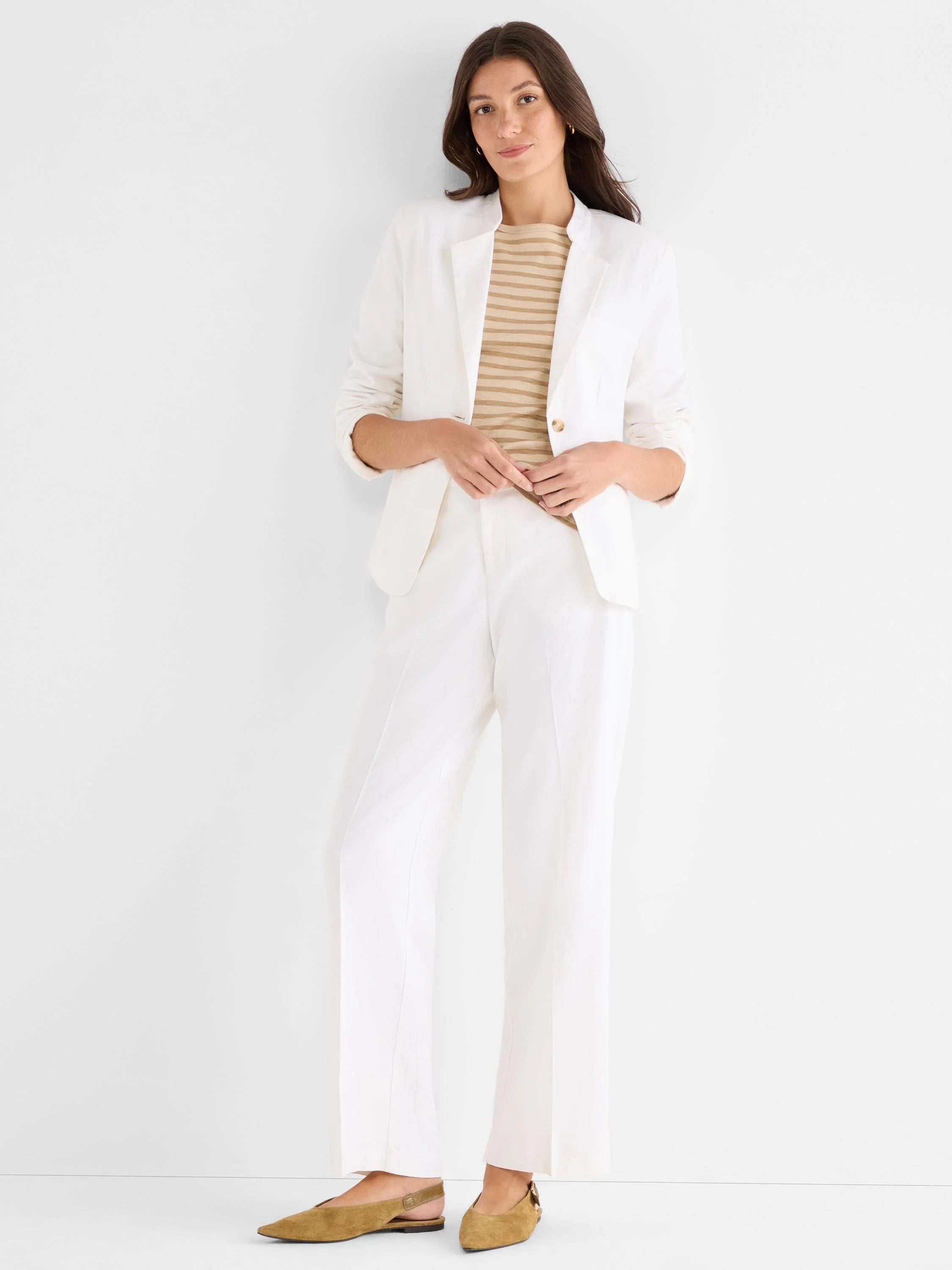 White wide-leg stretch linen pants with front creases, shown full-length on a model.