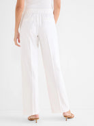 White wide-leg linen pants, back view. Features elasticated waist and subtle back pockets.