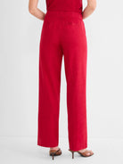 Red wide-leg linen pants on a model, shown from behind. Features an elasticated waist and two back pockets.