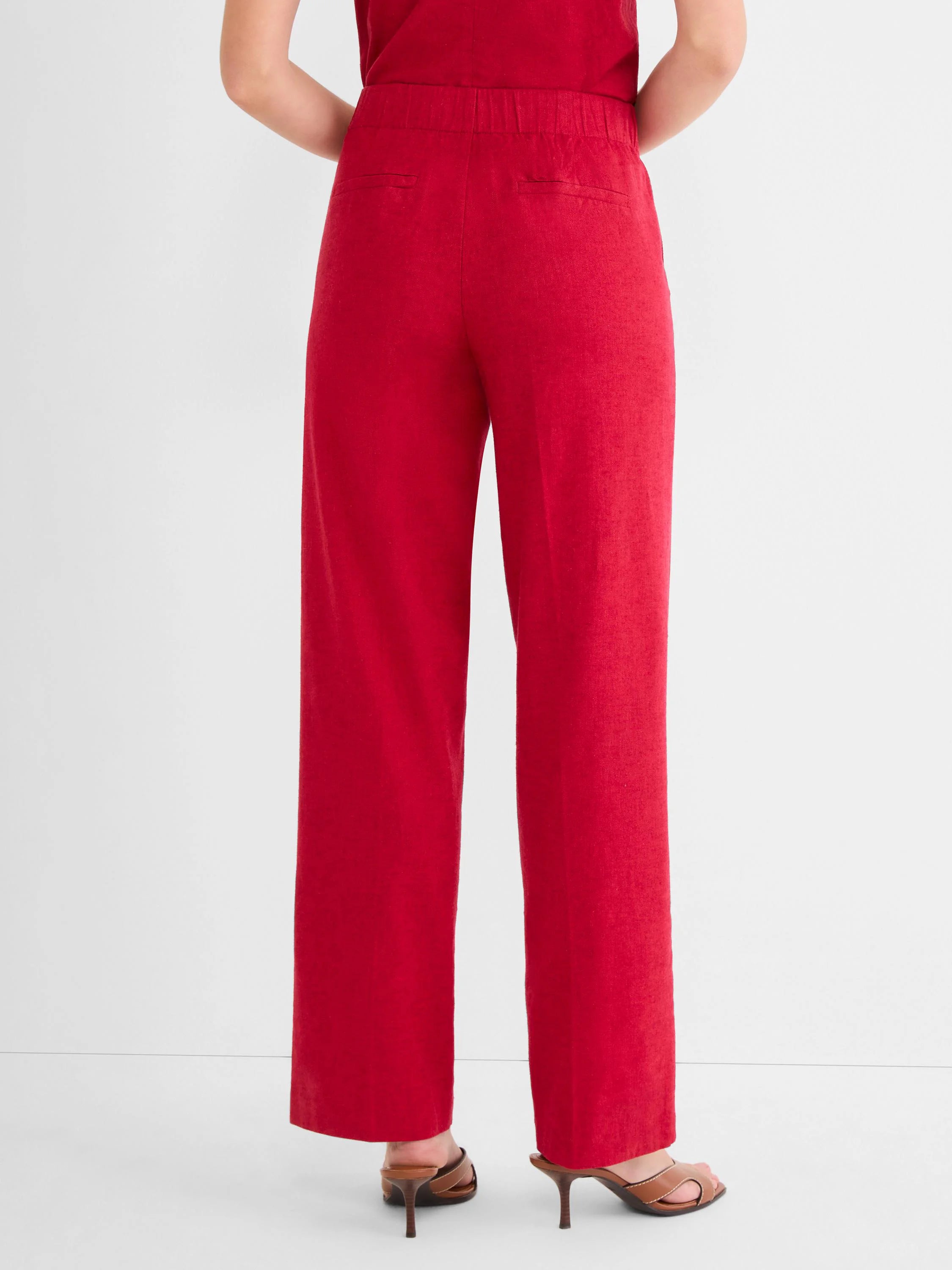Red wide-leg linen pants on a model, shown from behind. Features an elasticated waist and two back pockets.