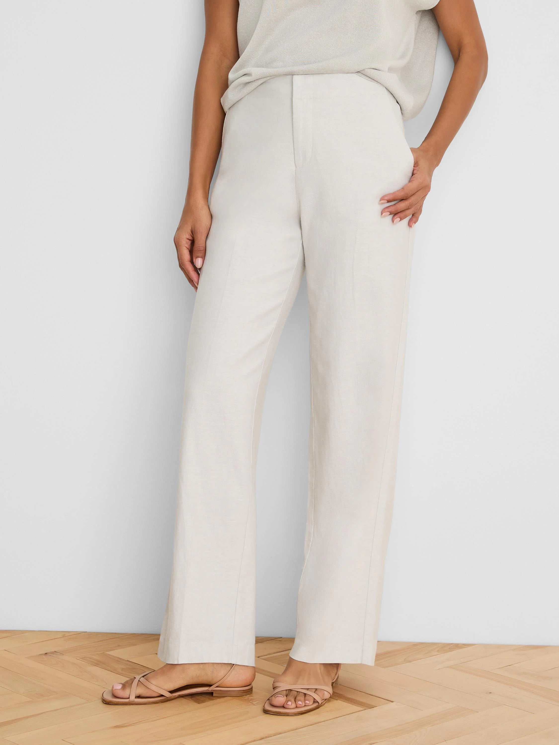 Cream, wide-leg linen pants on a model, showing flat front, full length, and visible linen texture.