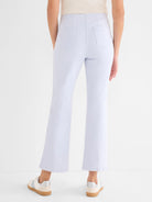 Pale blue high-waisted boot-cut jeans with back patch pockets and vertical leg seams.