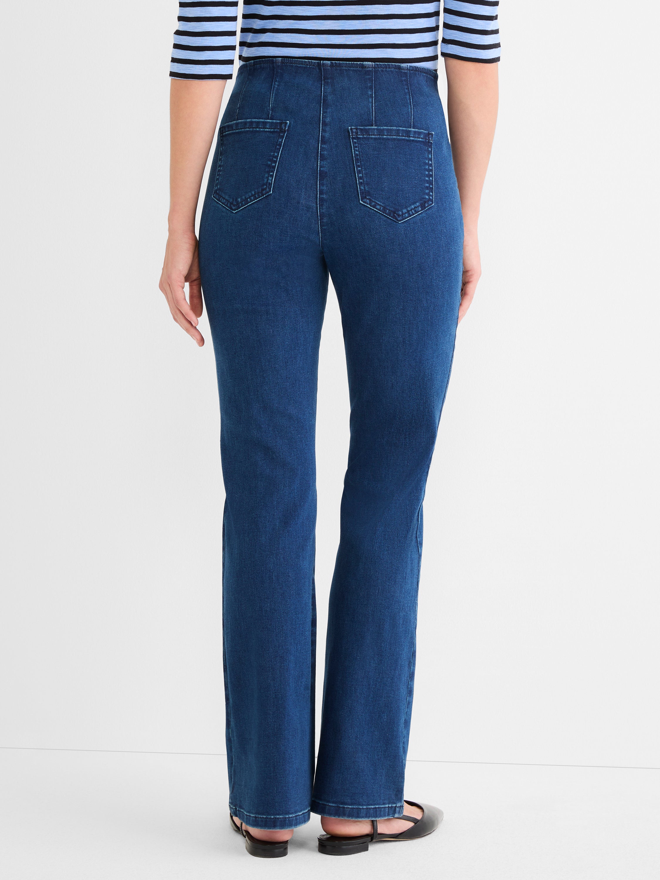 These high-waisted, dark wash blue jeans have a slim cut, back paneling, and square patch pockets.