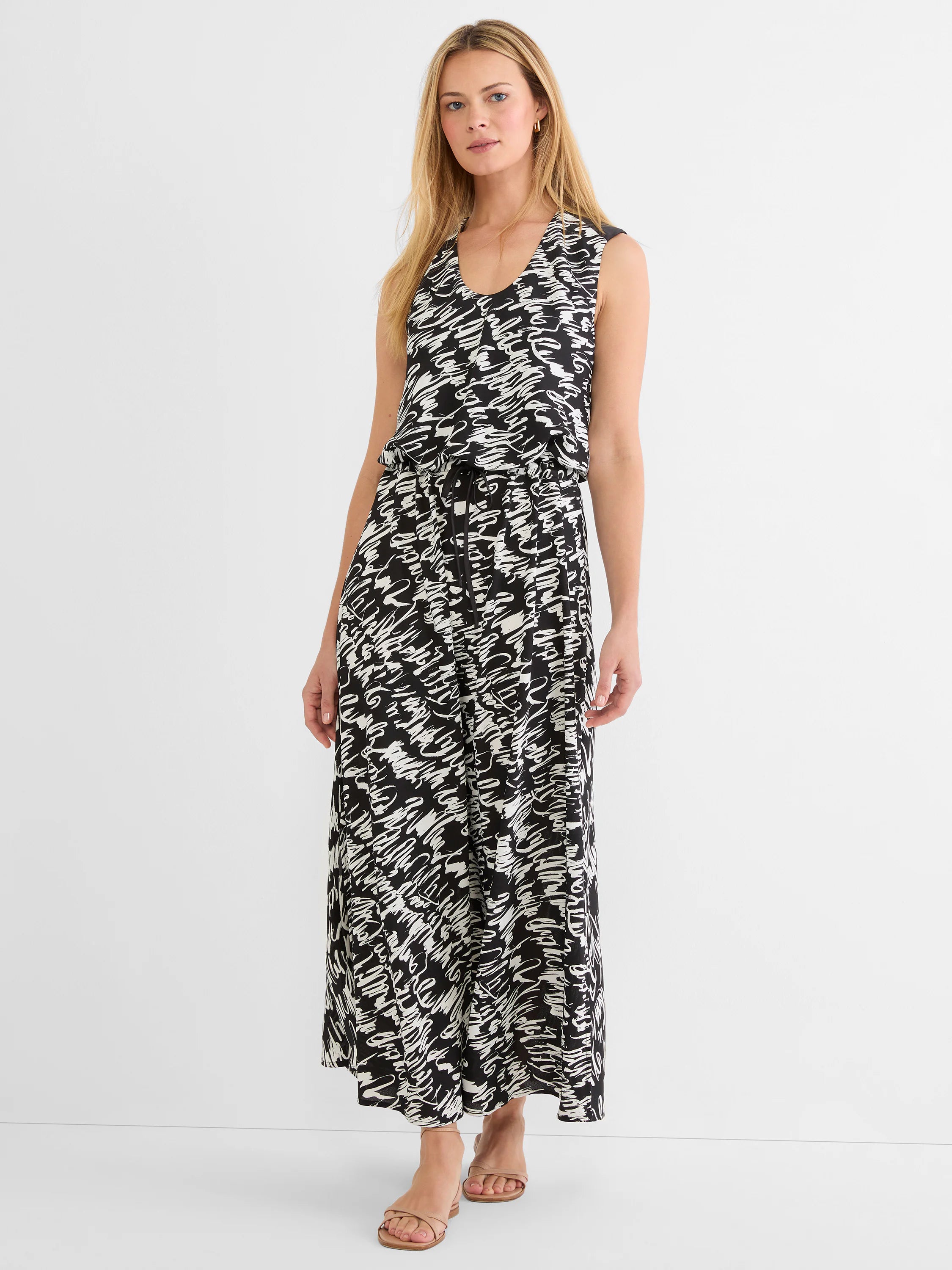 Black and white cursive pattern sleeveless maxi dress with a V-neck and drawstring waist on a model.